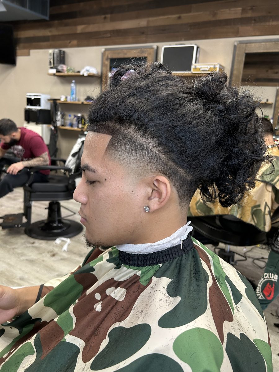 A finished cut by Barte: high fade with a long curly top and a sharp lineup