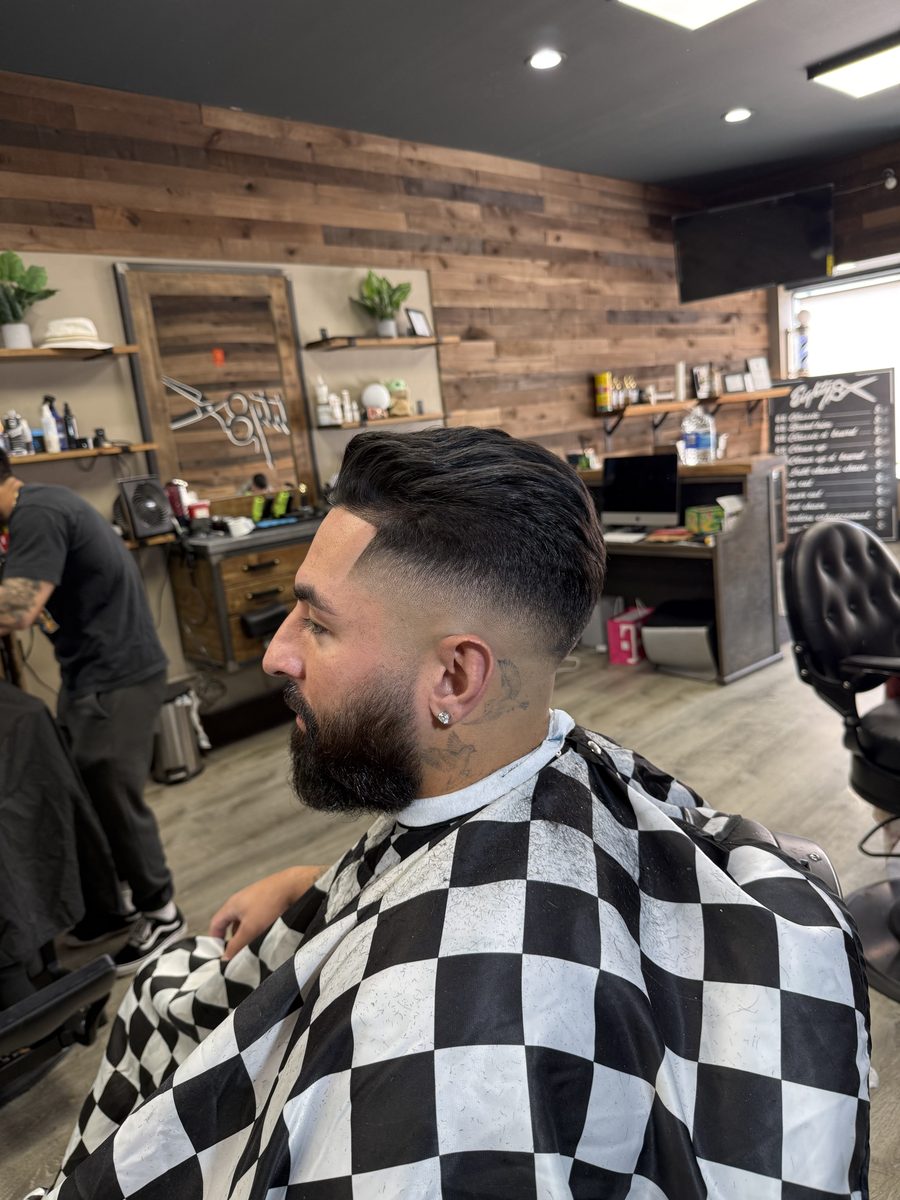 A finished cut by Barte: clean fade with a styled top and a shaped beard
